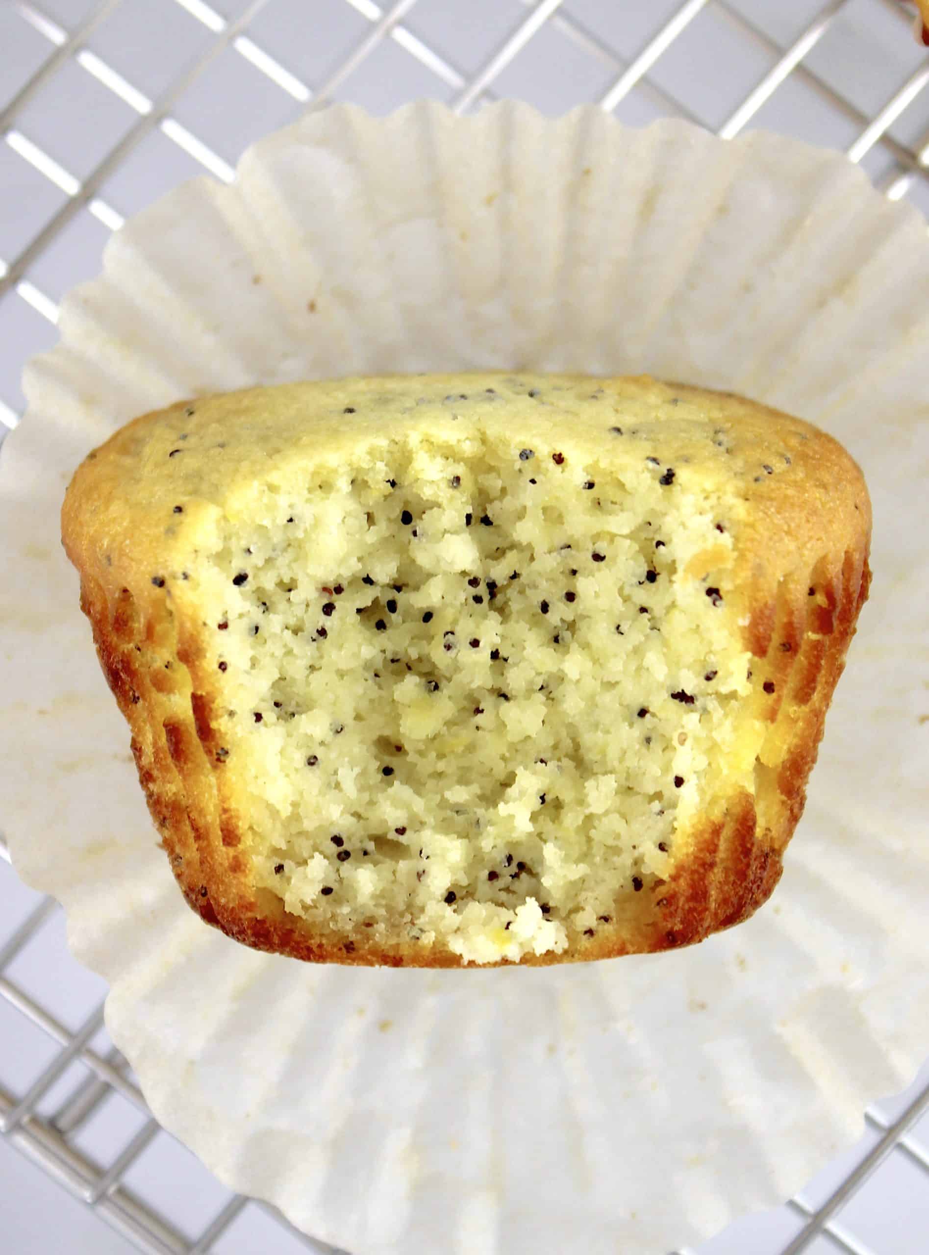 closeup of Keto Lemon Poppy Seed Muffin unwrapped with bite take out