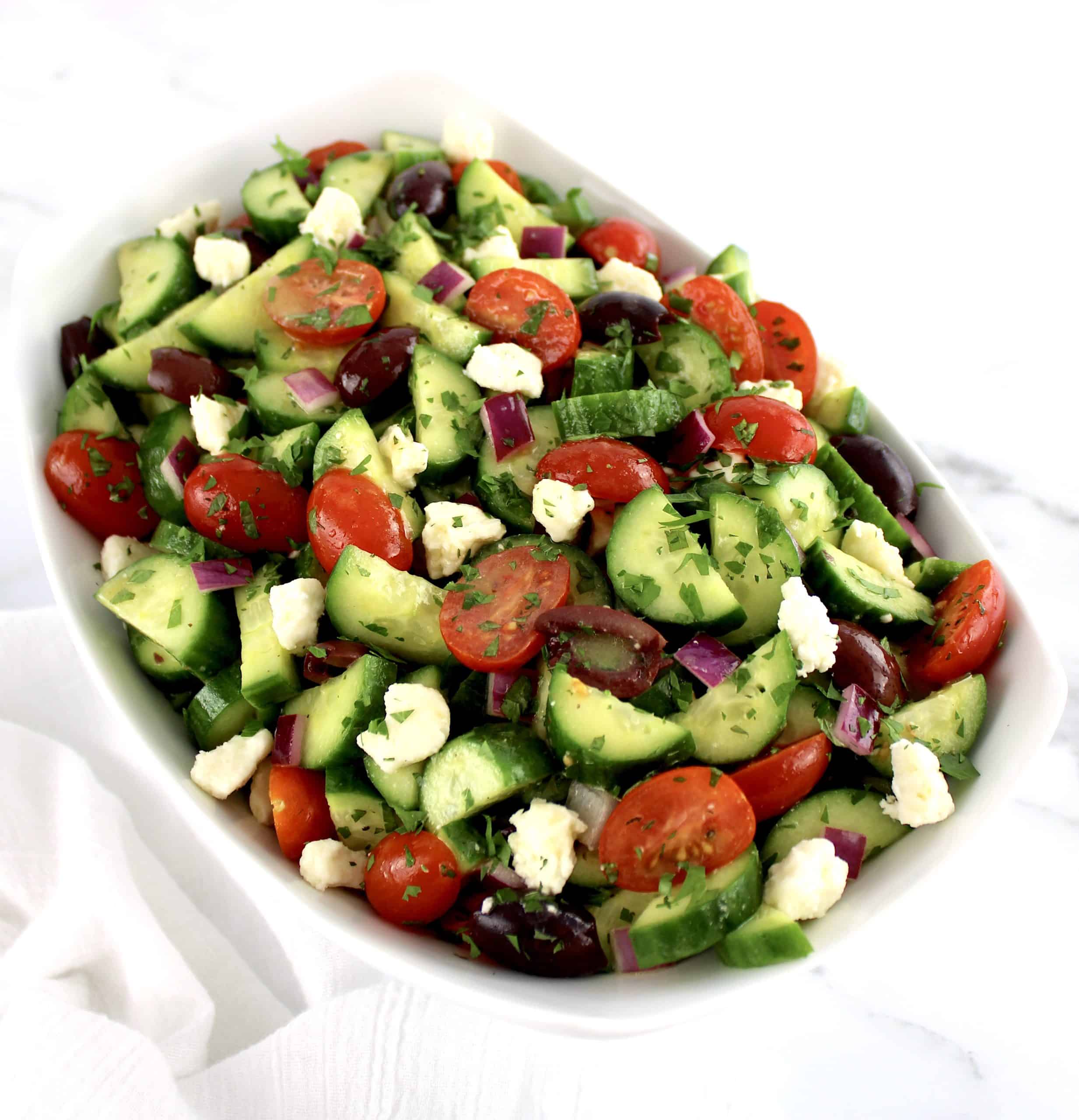Mediterranean Cucumber Salad with crumbled feta cheese in white bowl