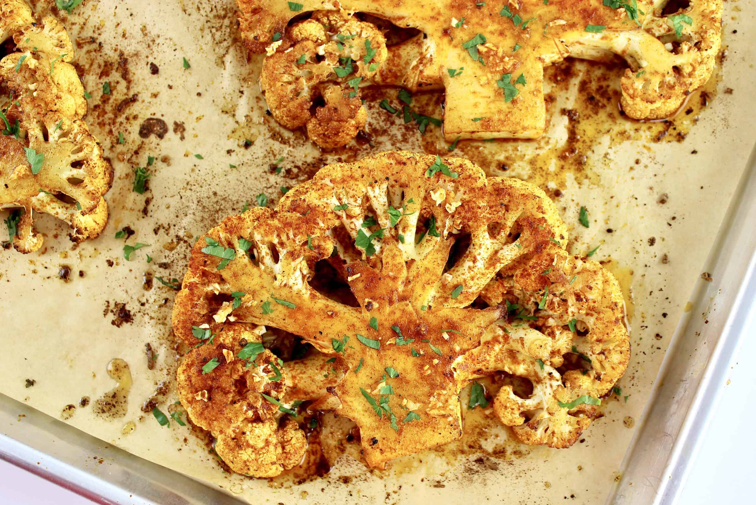 Roasted Cauliflower Steaks closeup on parchment lined baking sheet