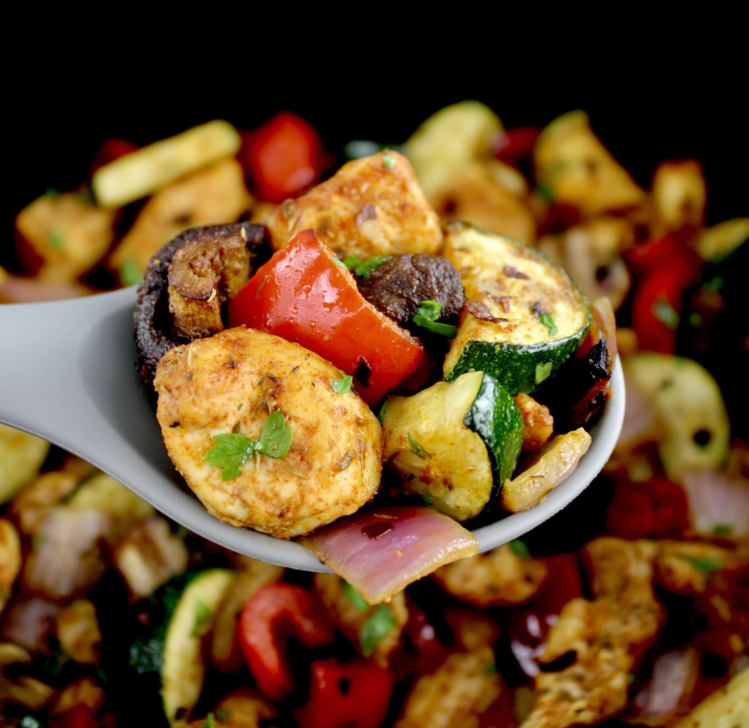 Air Fryer Chicken Bites with Veggies being held up with grey spoon