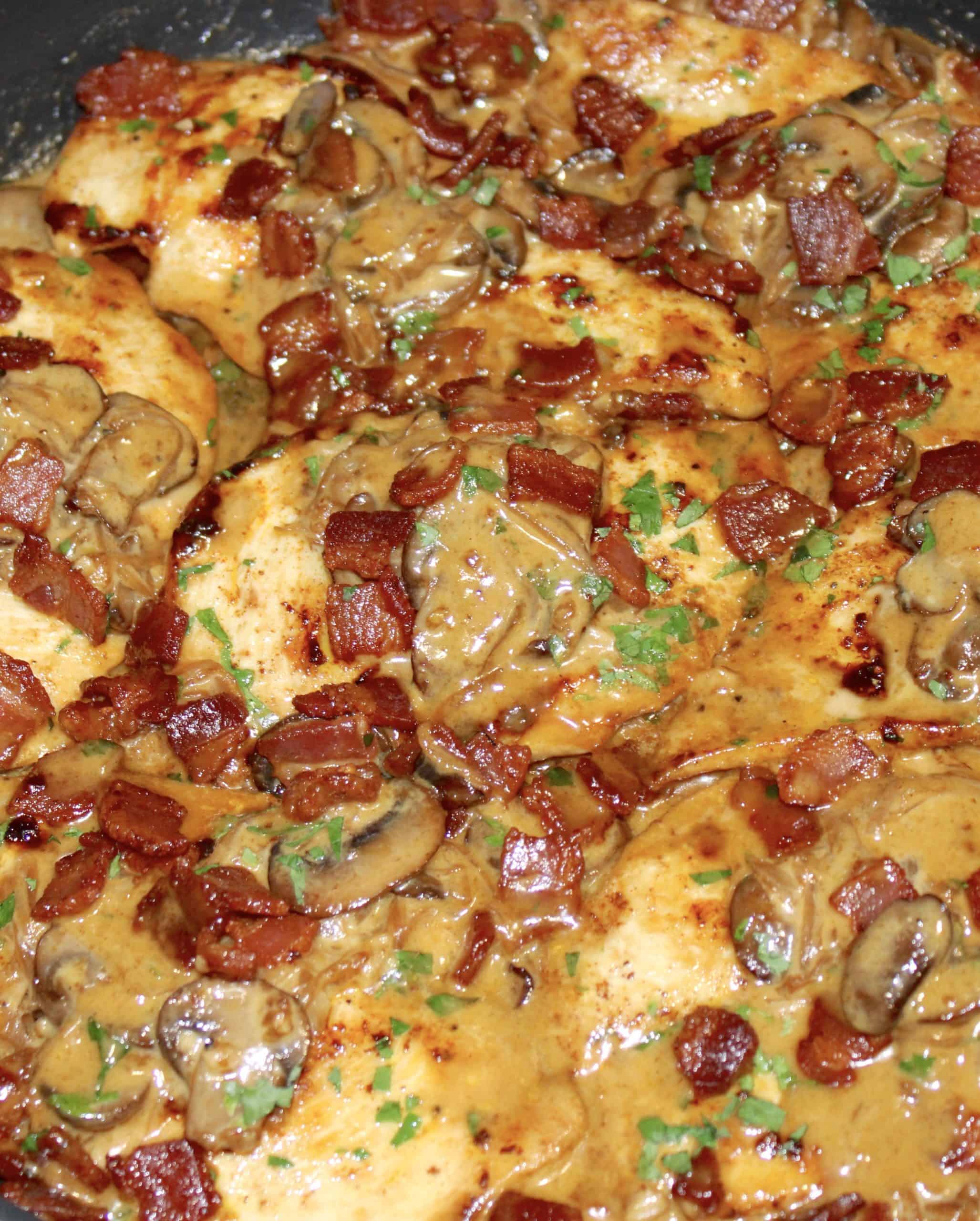 closeup of Creamy Bacon Mushroom Chicken with crispy bacon and parsley on top