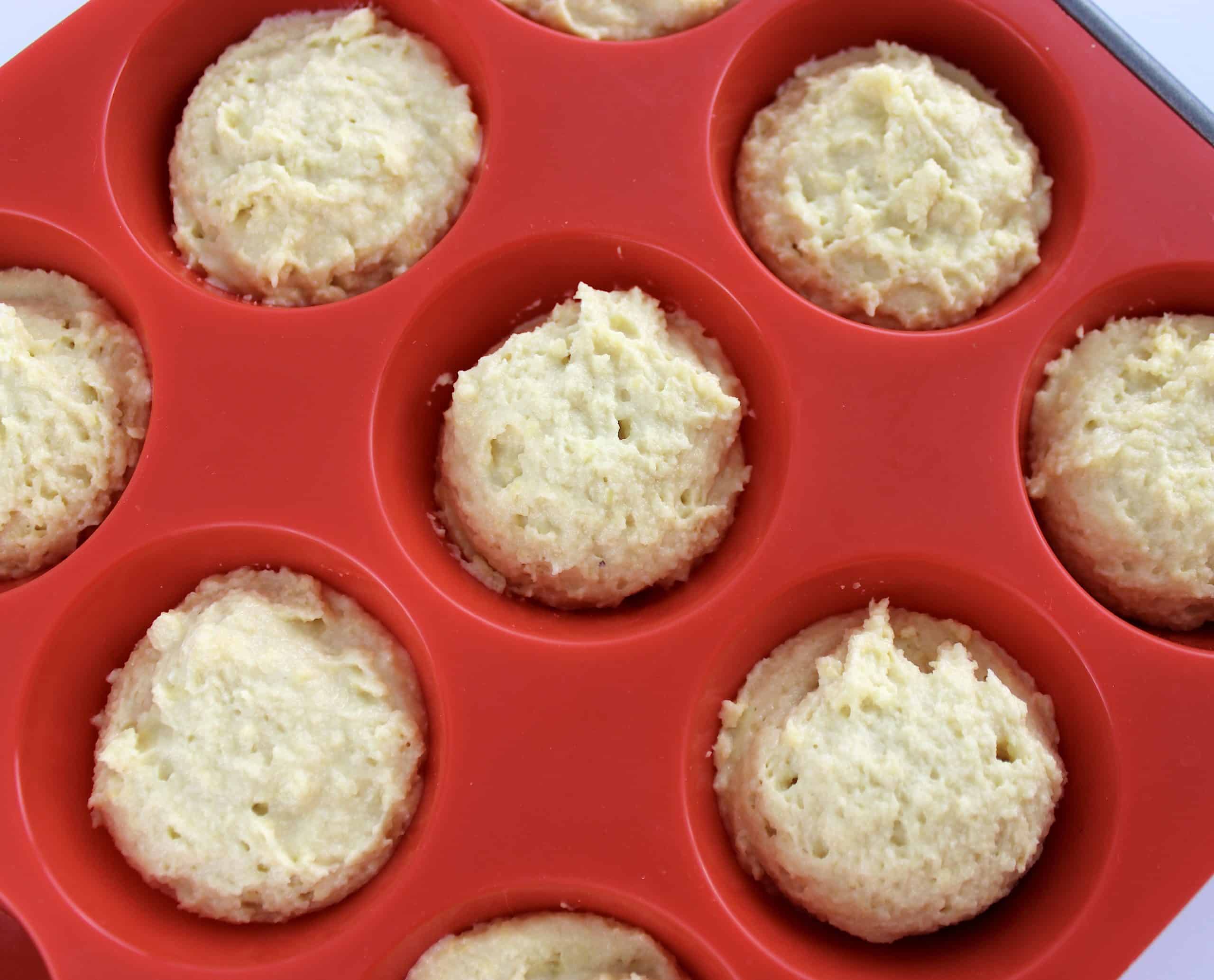 Keto Biscuits batter unbaked in red silicone muffin pan