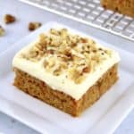 Keto Carrot Cake Bar on white square plate with bars on cooling rack in background