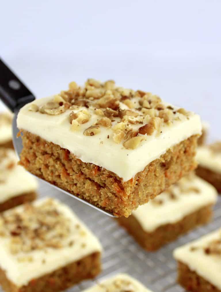 Keto Carrot Cake Bar held up by spatula with more bars in background on cooling rack