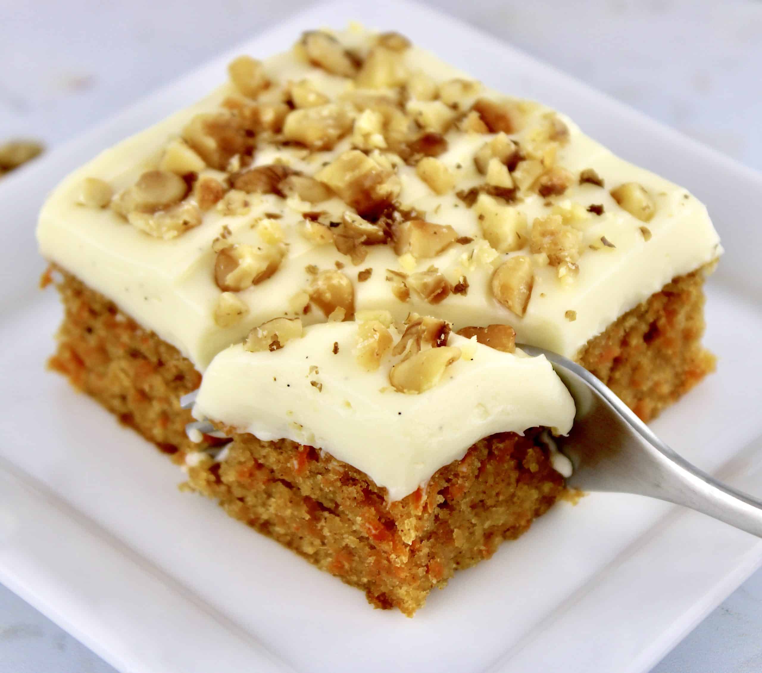 Keto Carrot Cake Bar on white square plate being cut into with fork