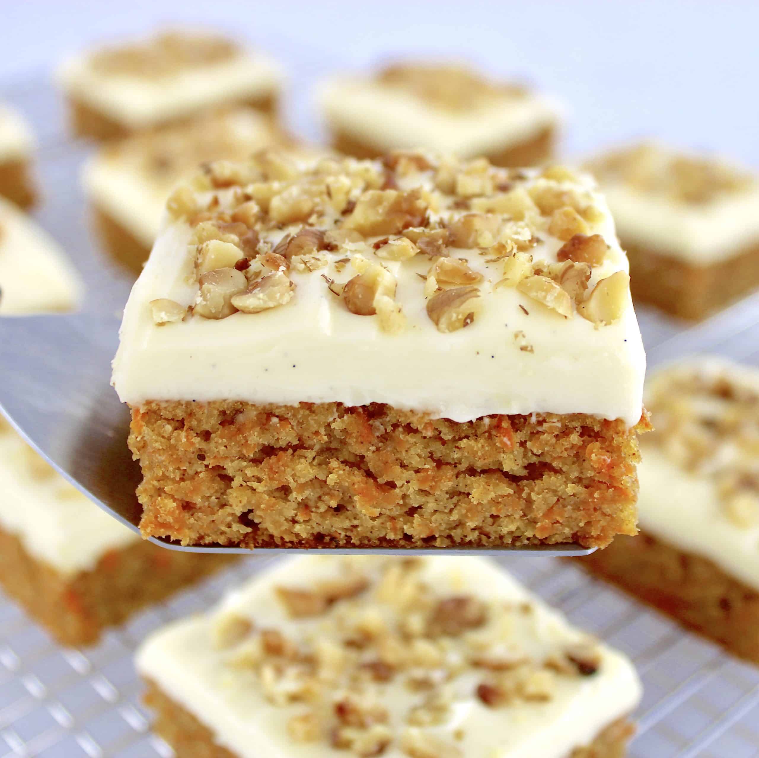Keto Carrot Cake Bar being held up with spatula with more bars in background