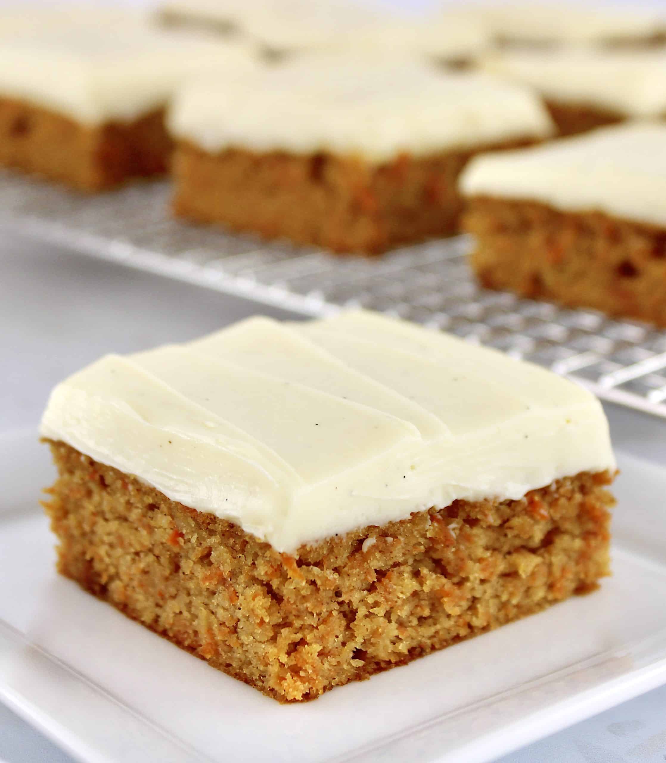 Keto Carrot Cake Bar on white square plate with more in background on cooling rack
