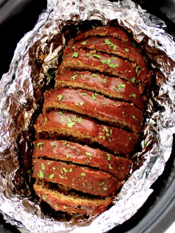 Keto Crockpot Meatloaf with tomato glaze on top sliced in foil lined crockpot