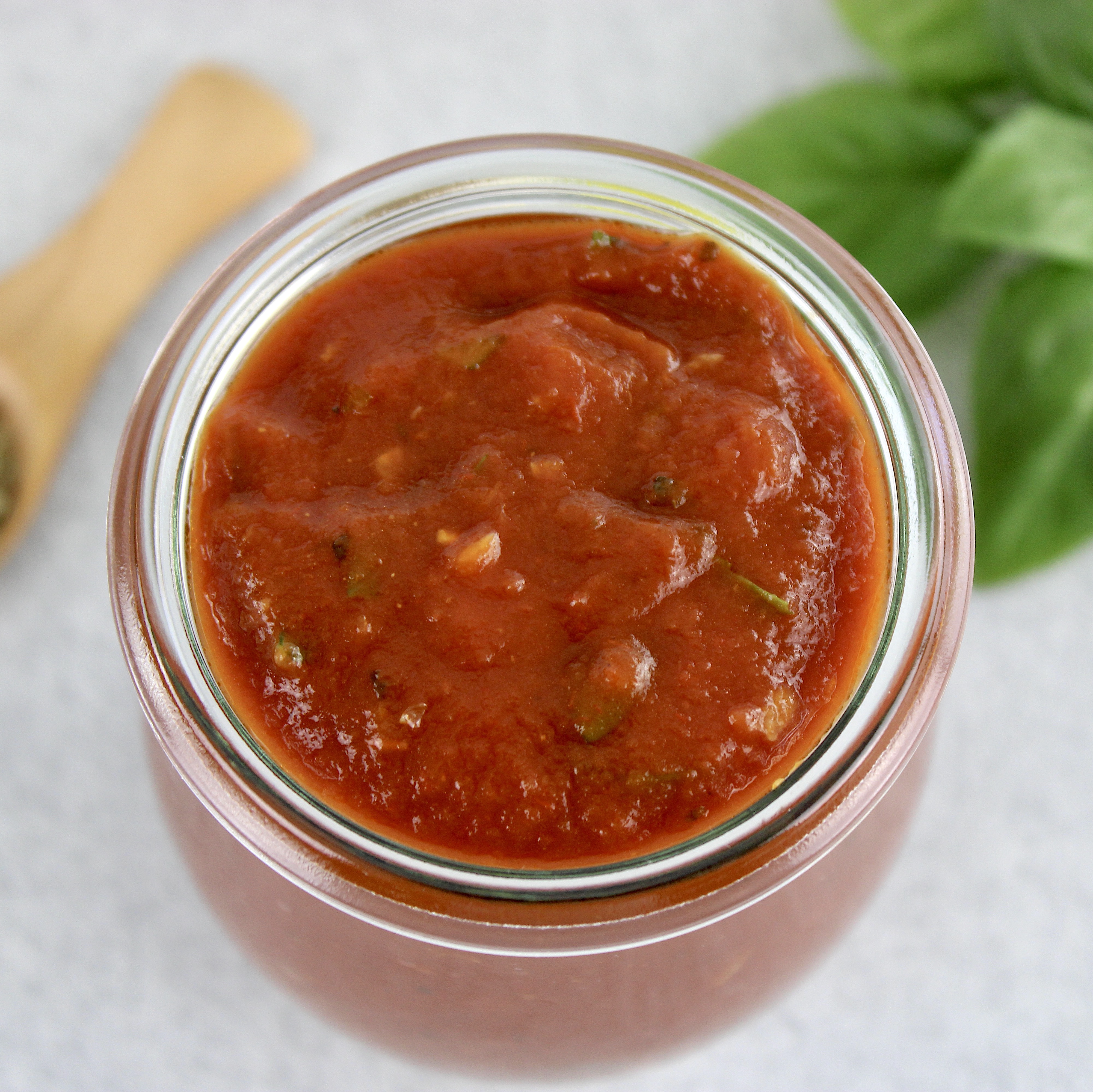 overhead view of pizza sauce in open glass jar
