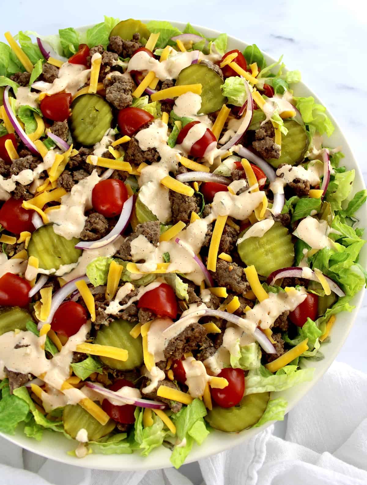 overhead view of Big Mac Cheeseburger Salad in beige bowl