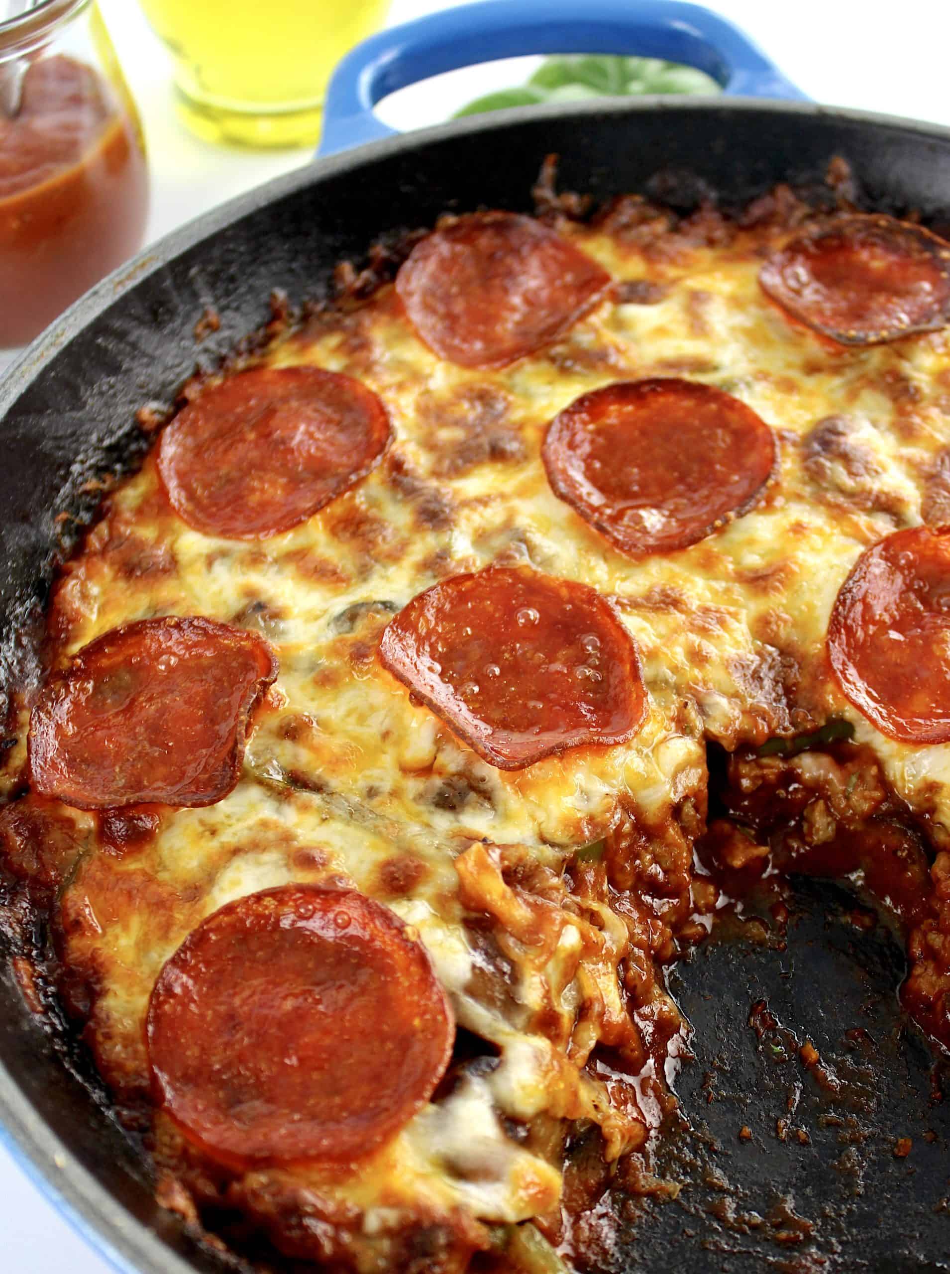 Crustless Pizza with pepperoni in skillet with piece missing