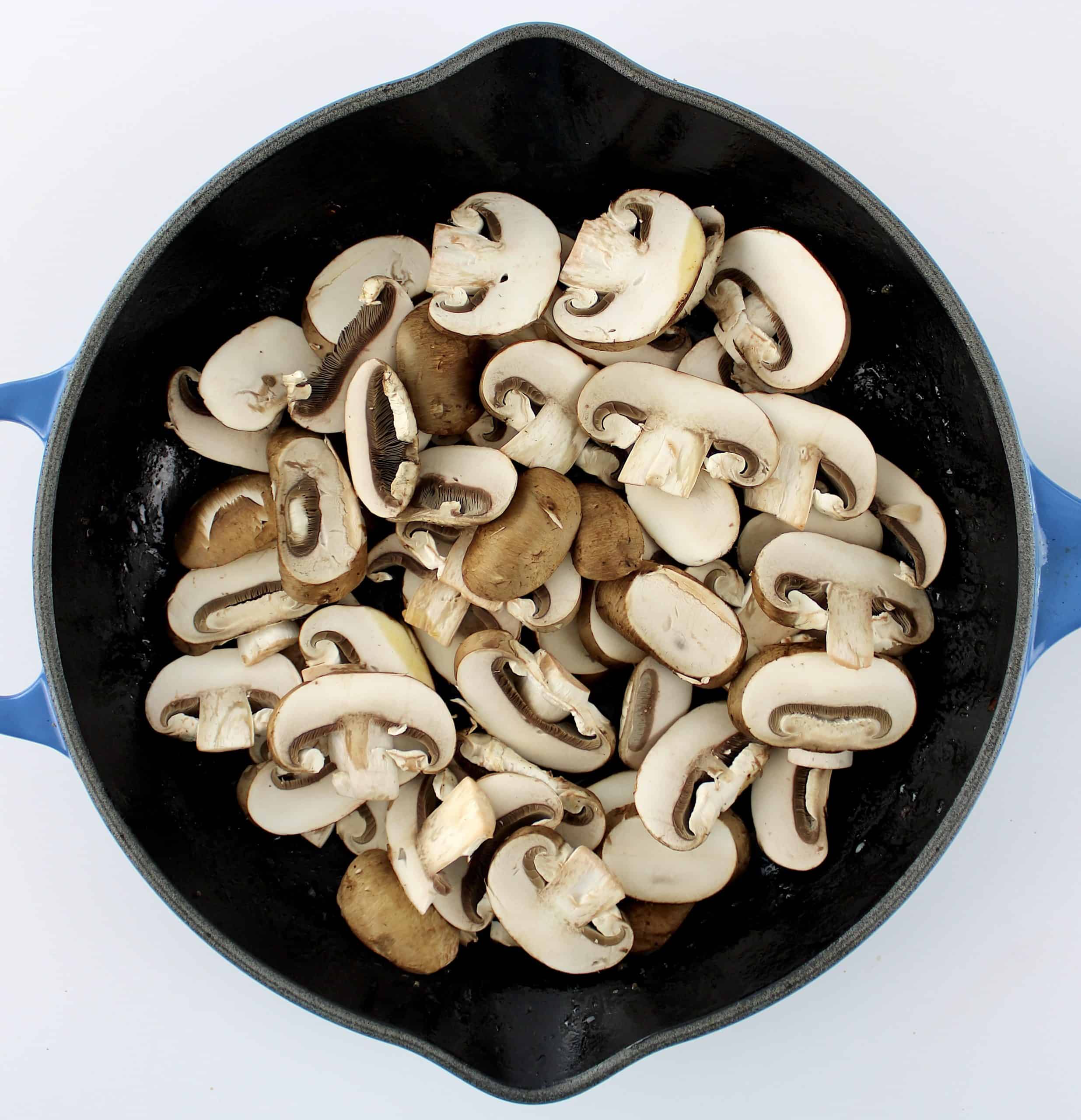 slices of baby bella mushrooms in skillet uncooked