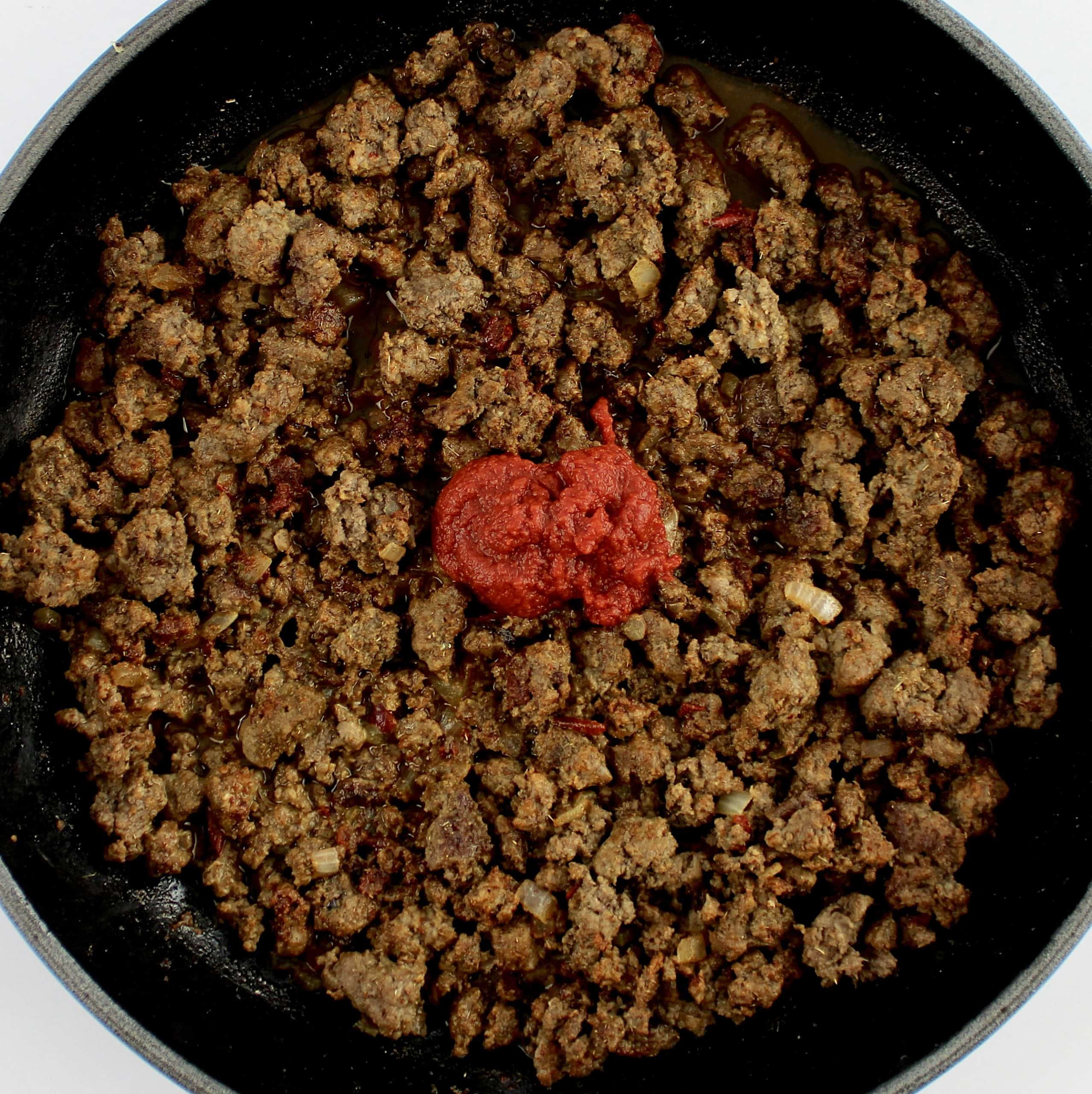 taco meat in skillet with tomato paste on top
