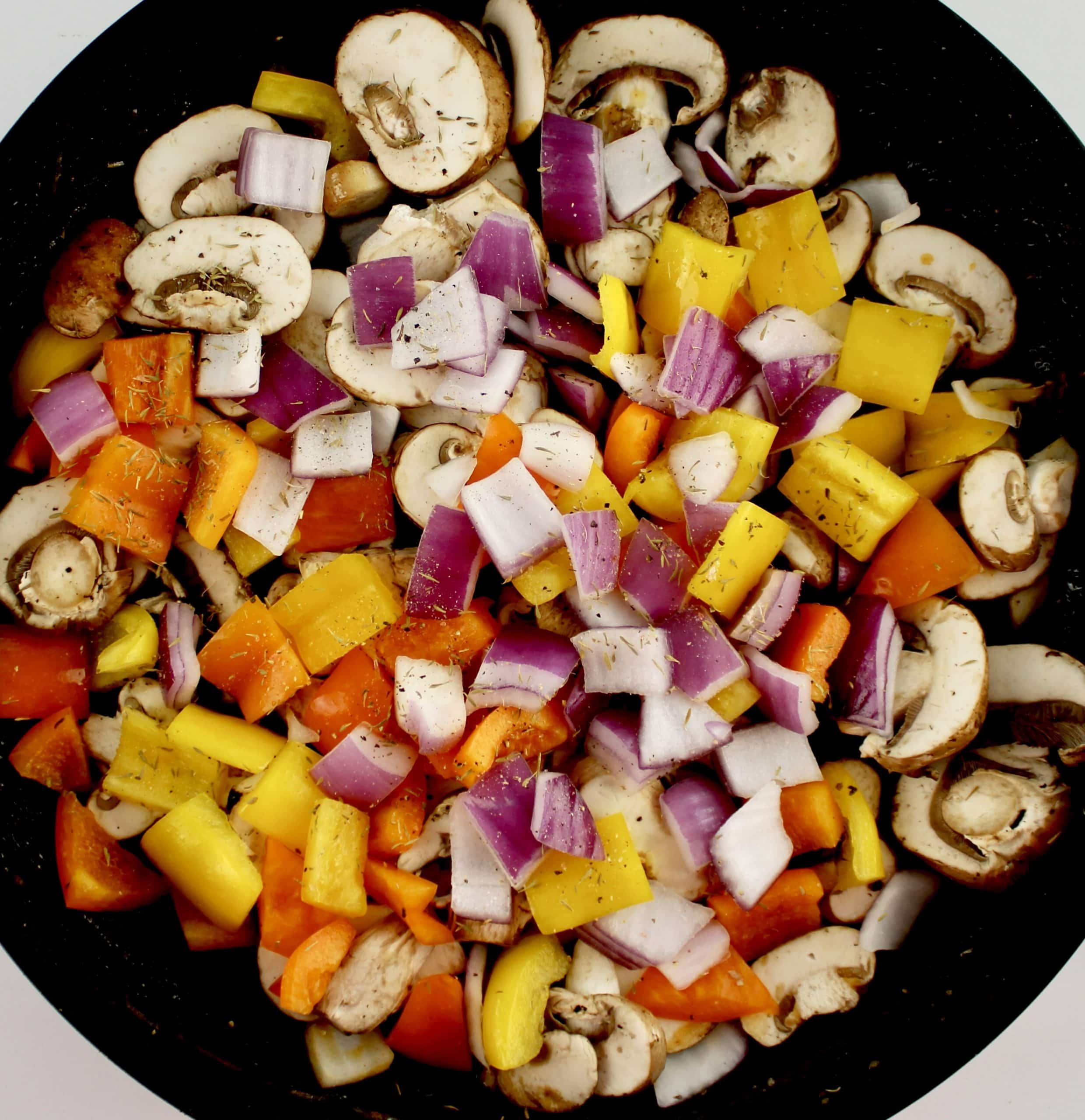 chopped red onion peppers and mushrooms in skillet uncooked