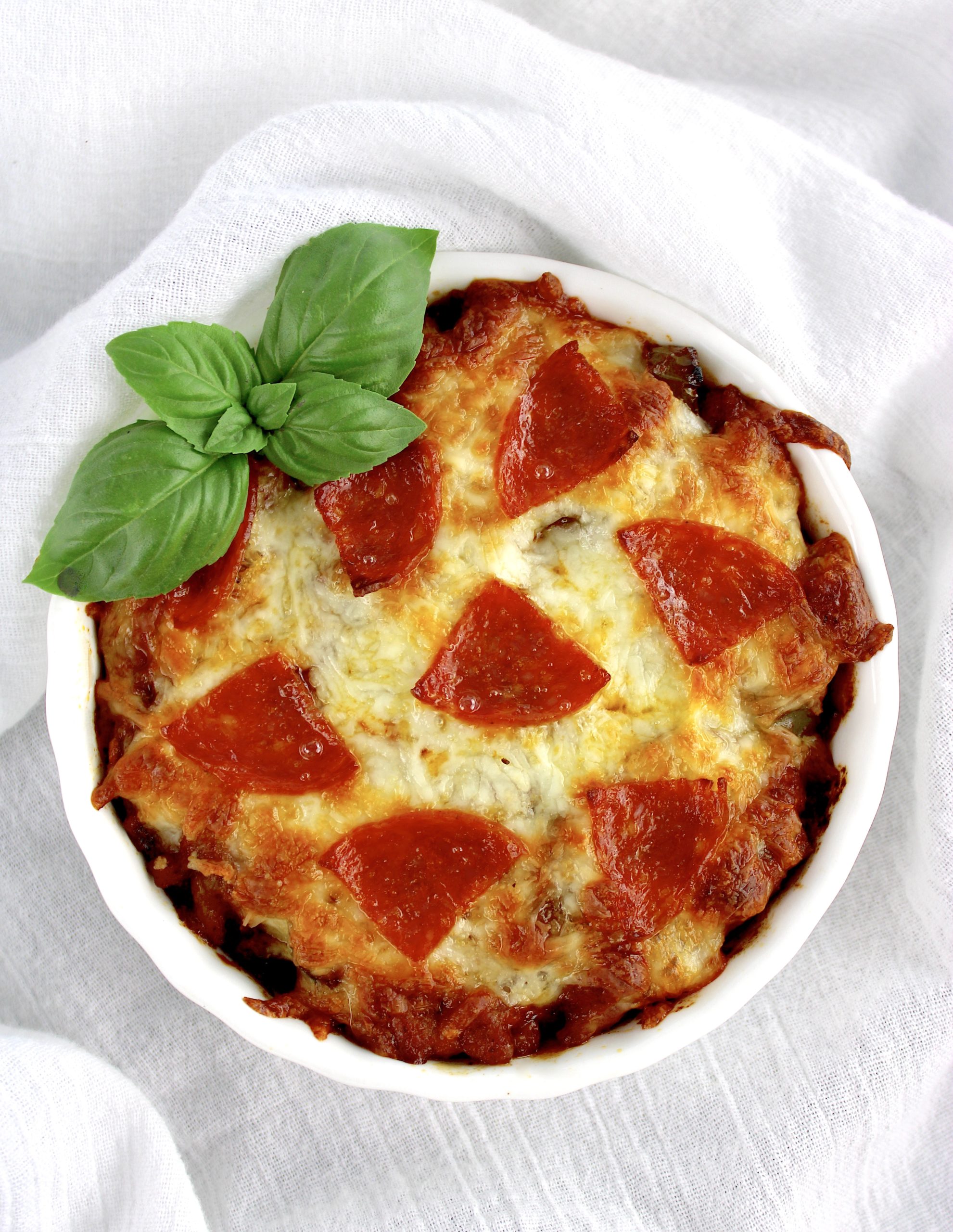 overhead view of Pizza Bowl i white ramekin with basil leaves