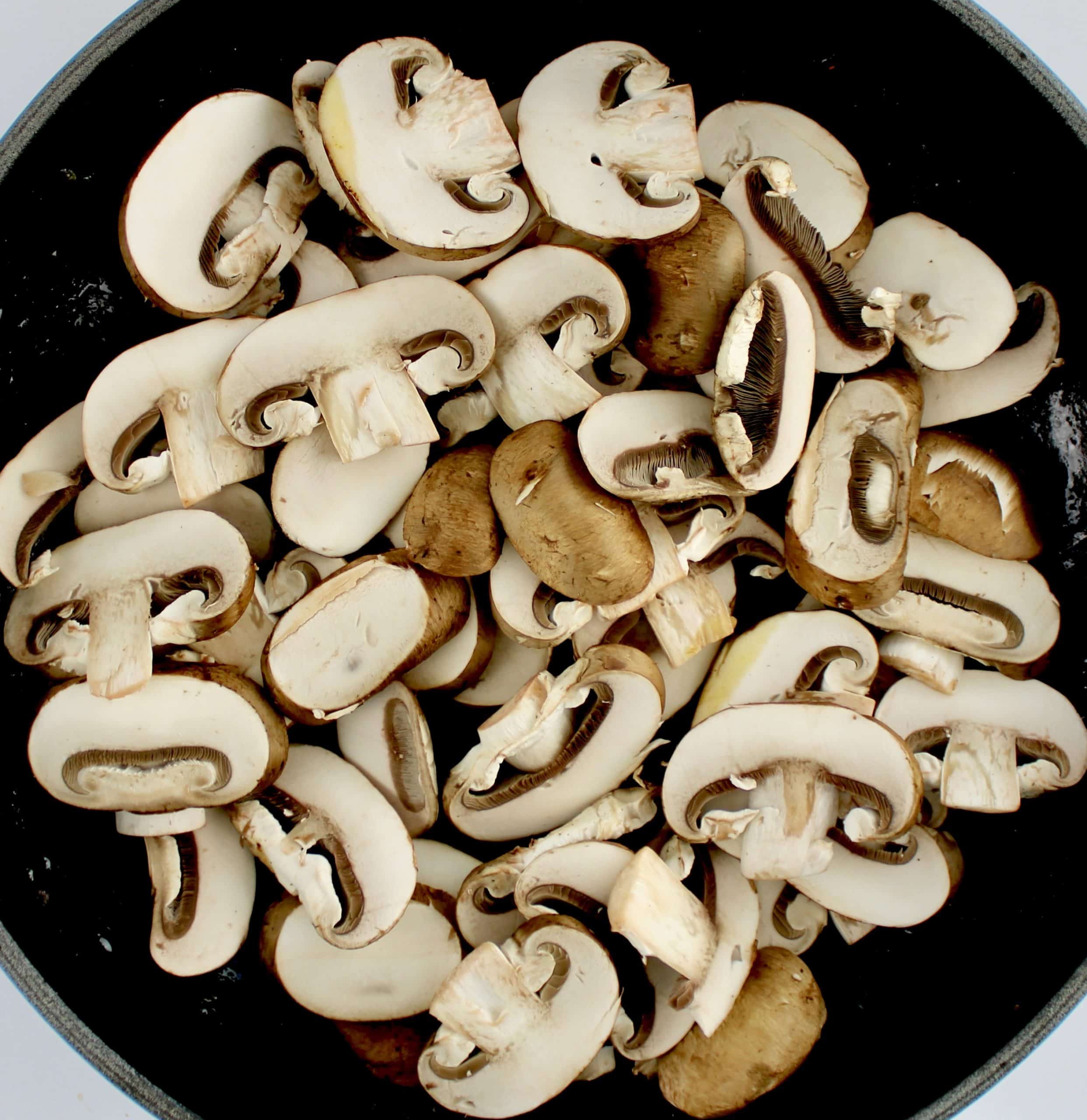 slices of baby bella mushrooms in skillet uncooked