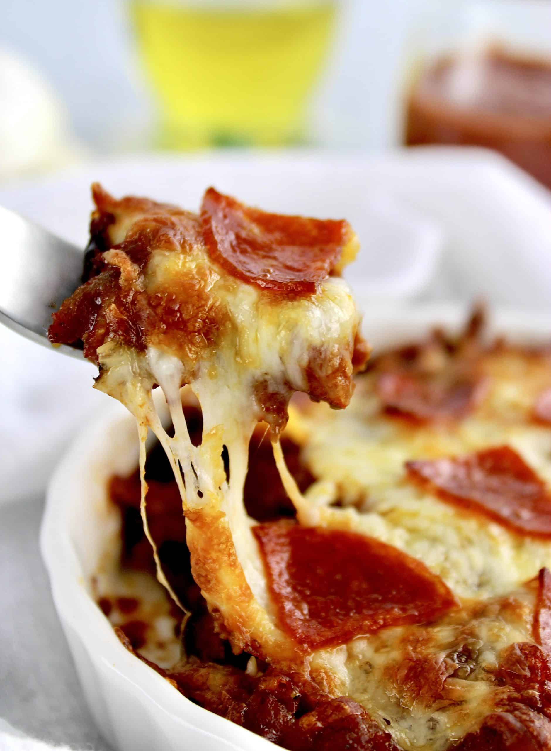 fork digging into Pizza Bowl with pepperoni and pulling cheese up