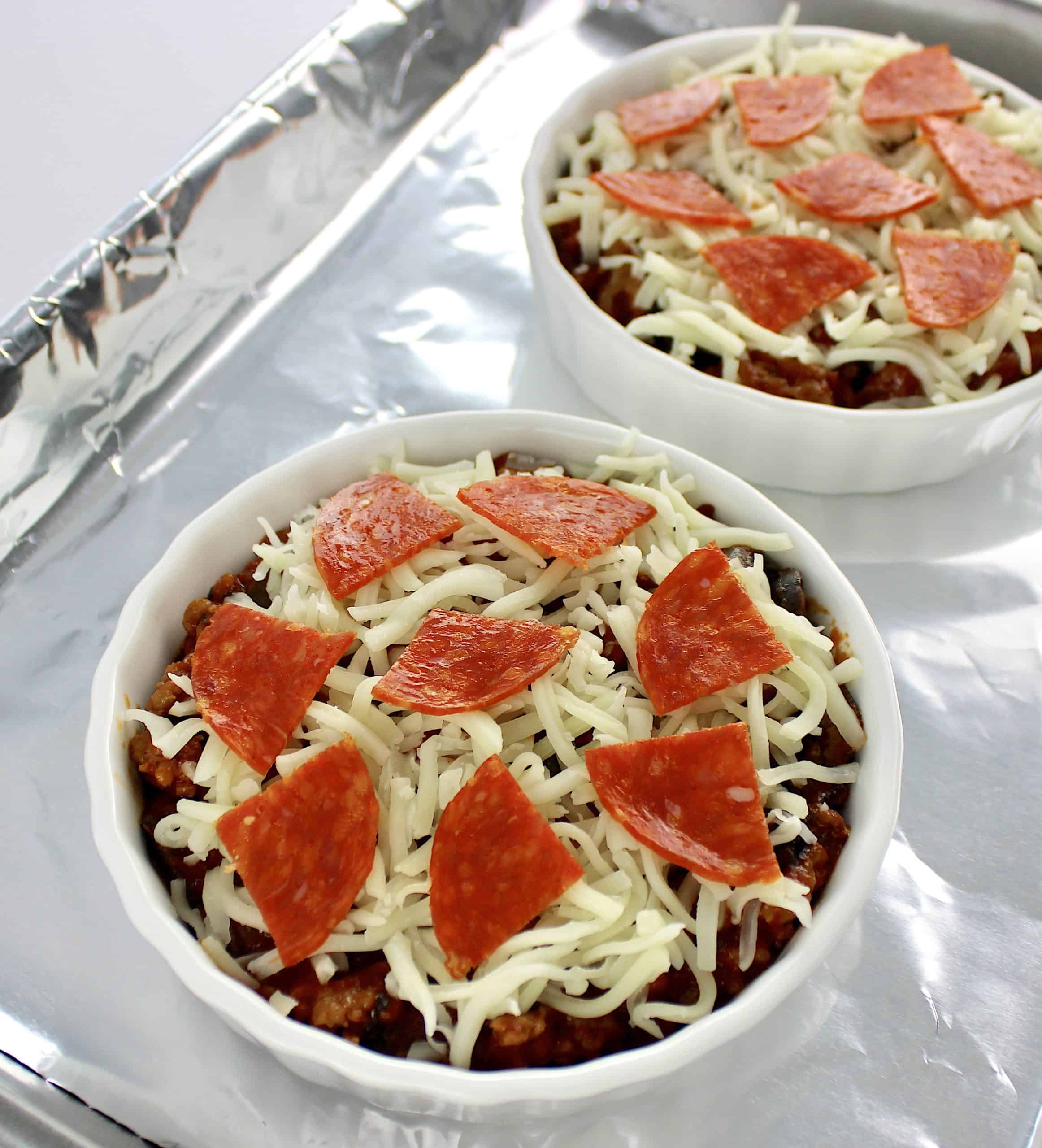 pepperoni Pizza Bowls i white ramekins on foil lined baking sheet uncooked