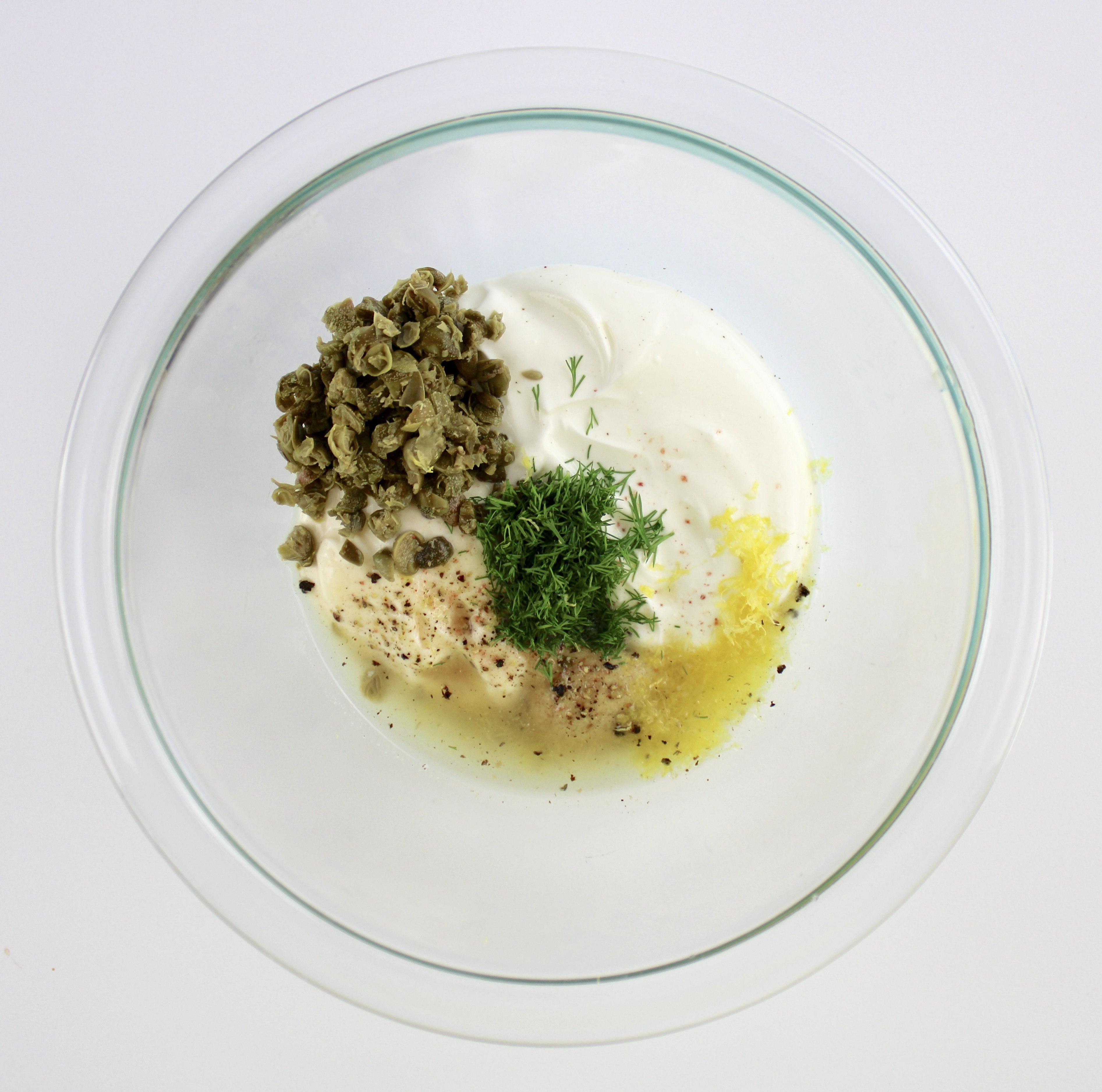 creamy dill sauce ingredients in glass mixing bowl