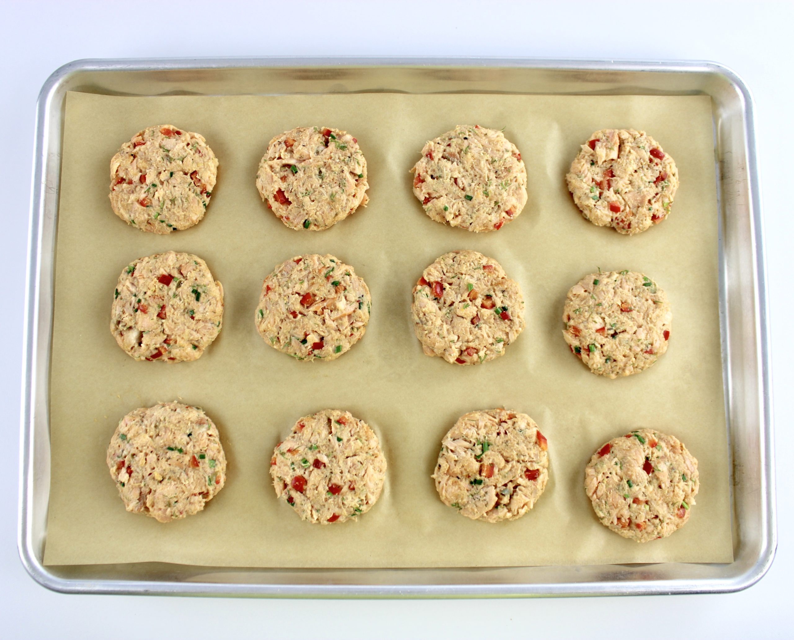 12 salmon patties on parchment lined baking sheet