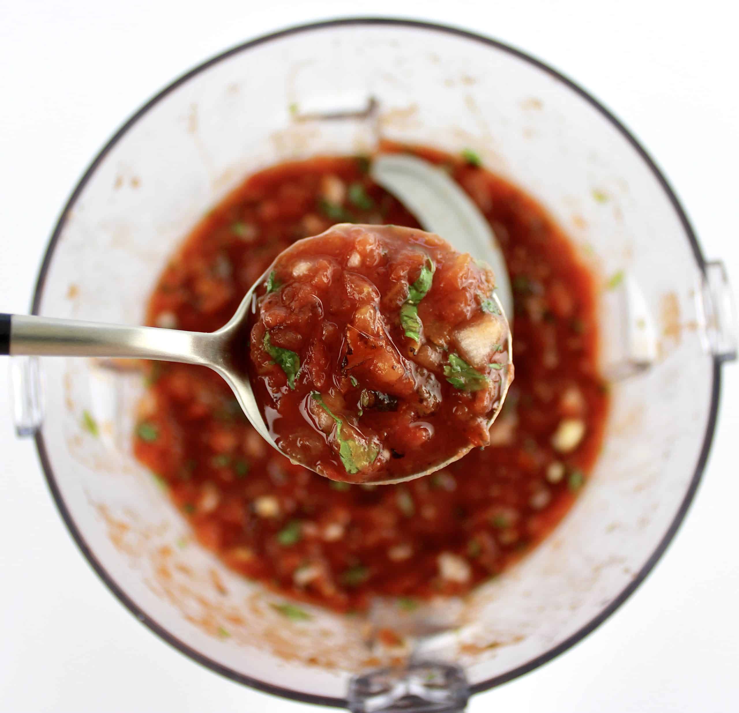 salsa in spoon held up over food processor bowl