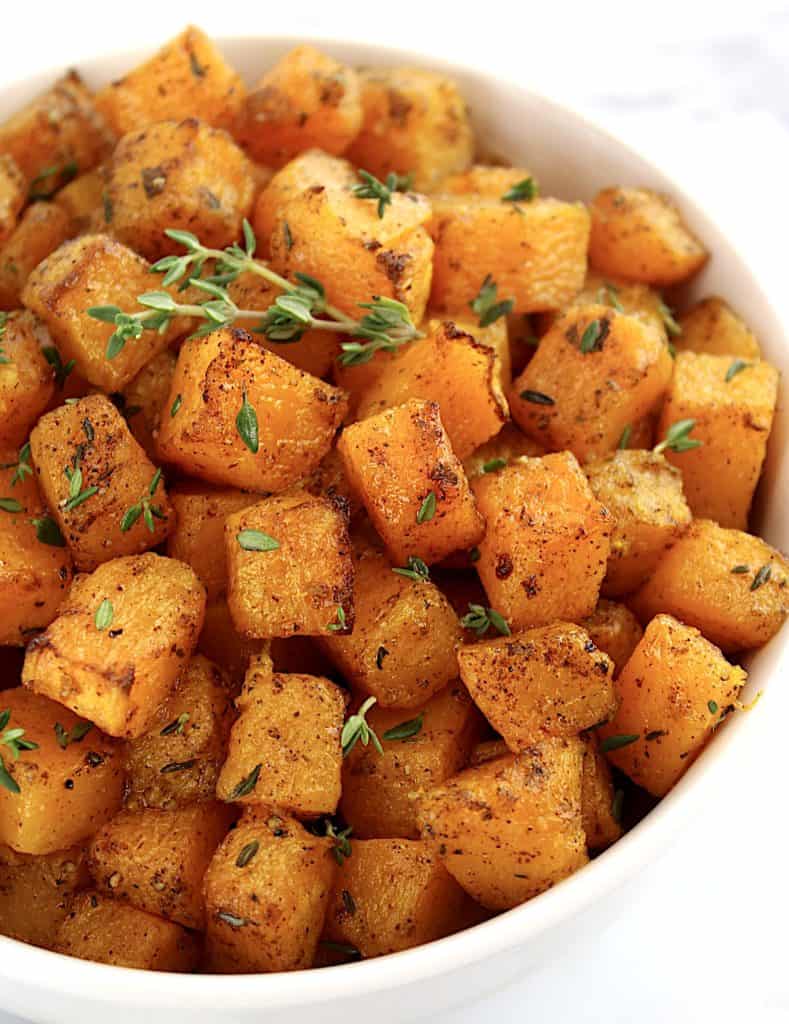 Air Fryer Butternut Squash in white bowl with fresh thyme on top