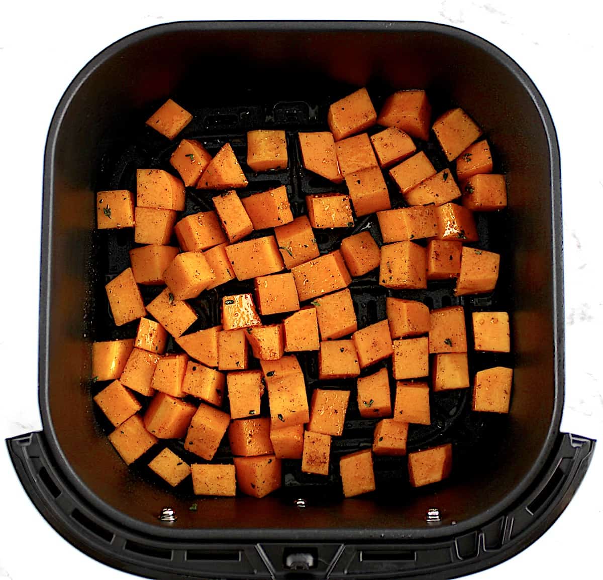 seasoned butternut squash cubes in air fryer uncooked