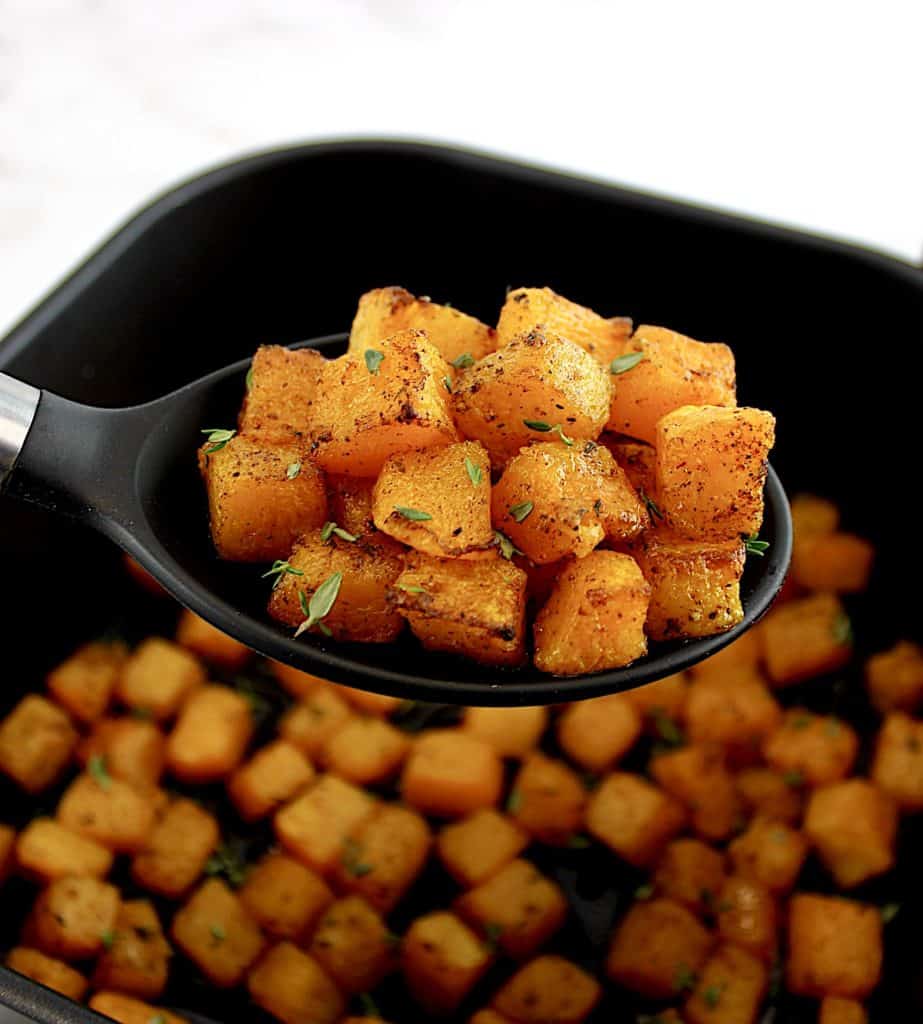 Air Fryer Butternut Squash being held up with black spoon