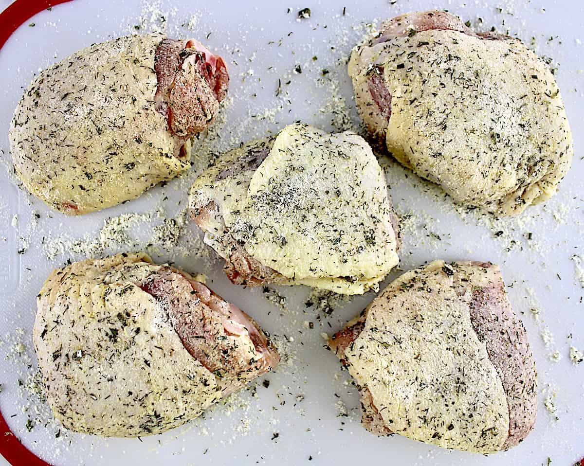5 raw chicken thighs with ranch seasoning on cutting board