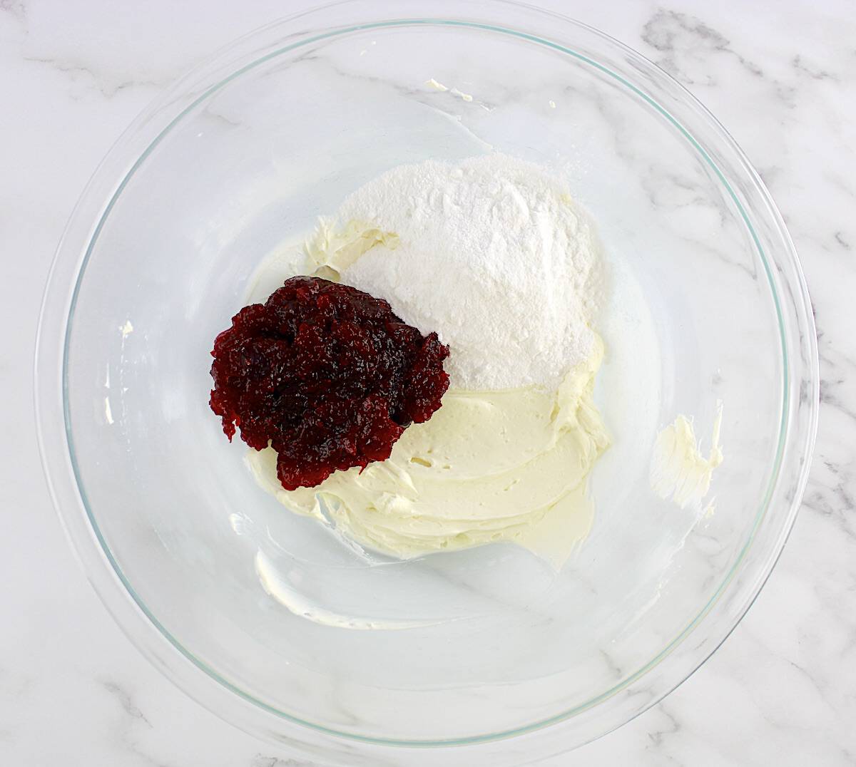 cream cheese, sweetener and cranberry sauce unmixed in glass bowl