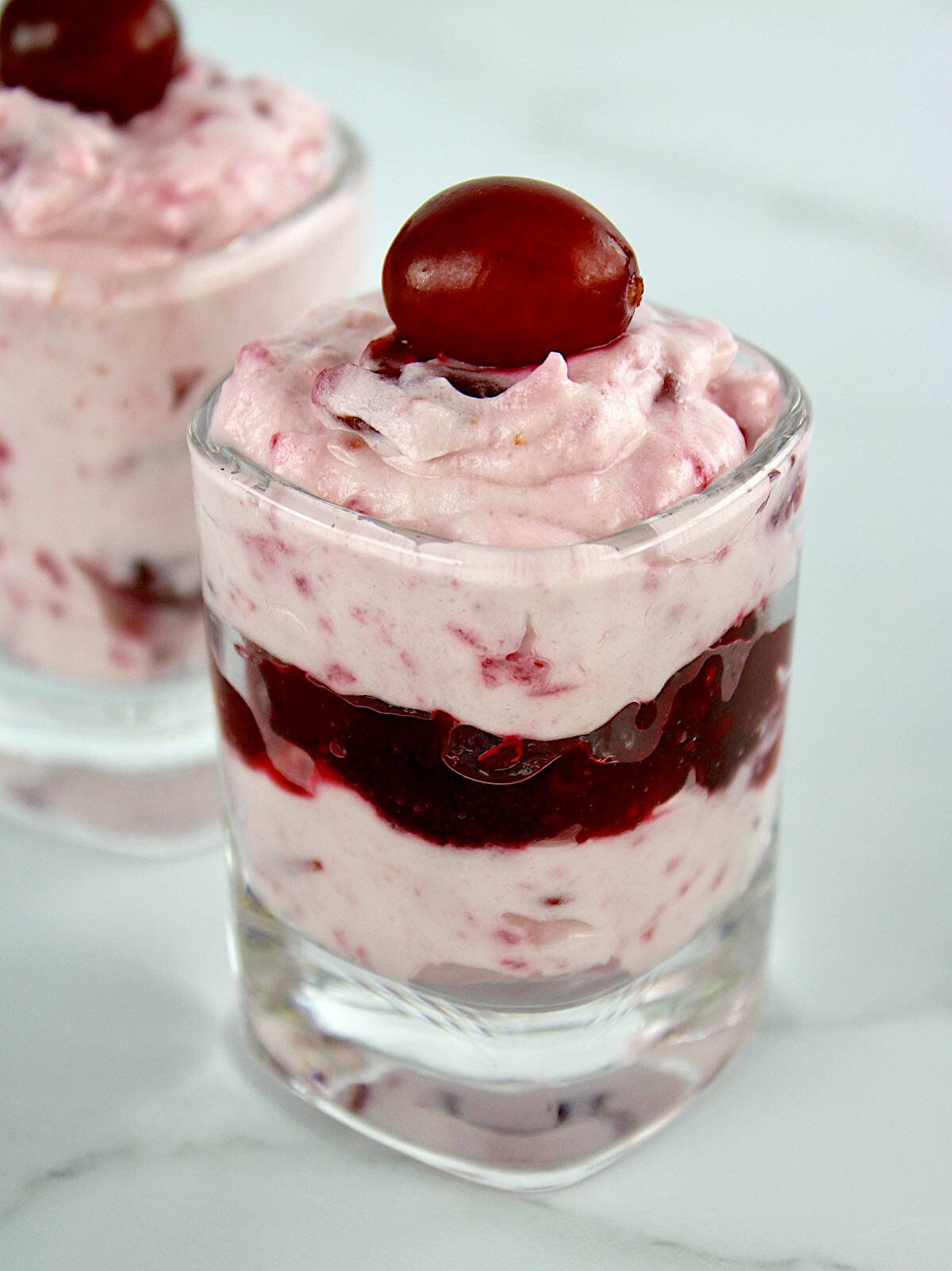 Cranberry Cheesecake Fluff layered in shot glass with cranberry on top