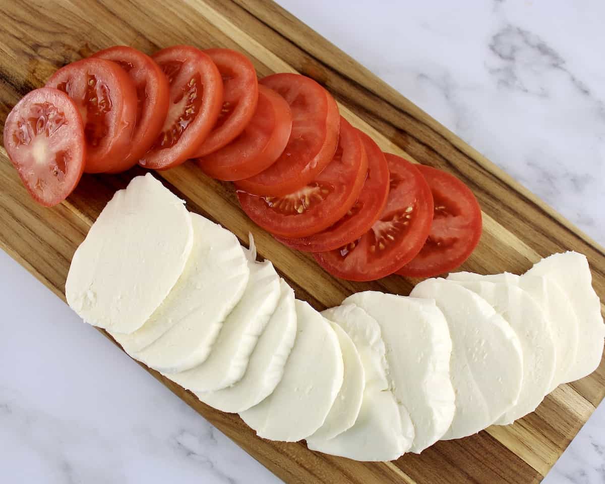 slices of tomato and mozzarella cheese on cutting board