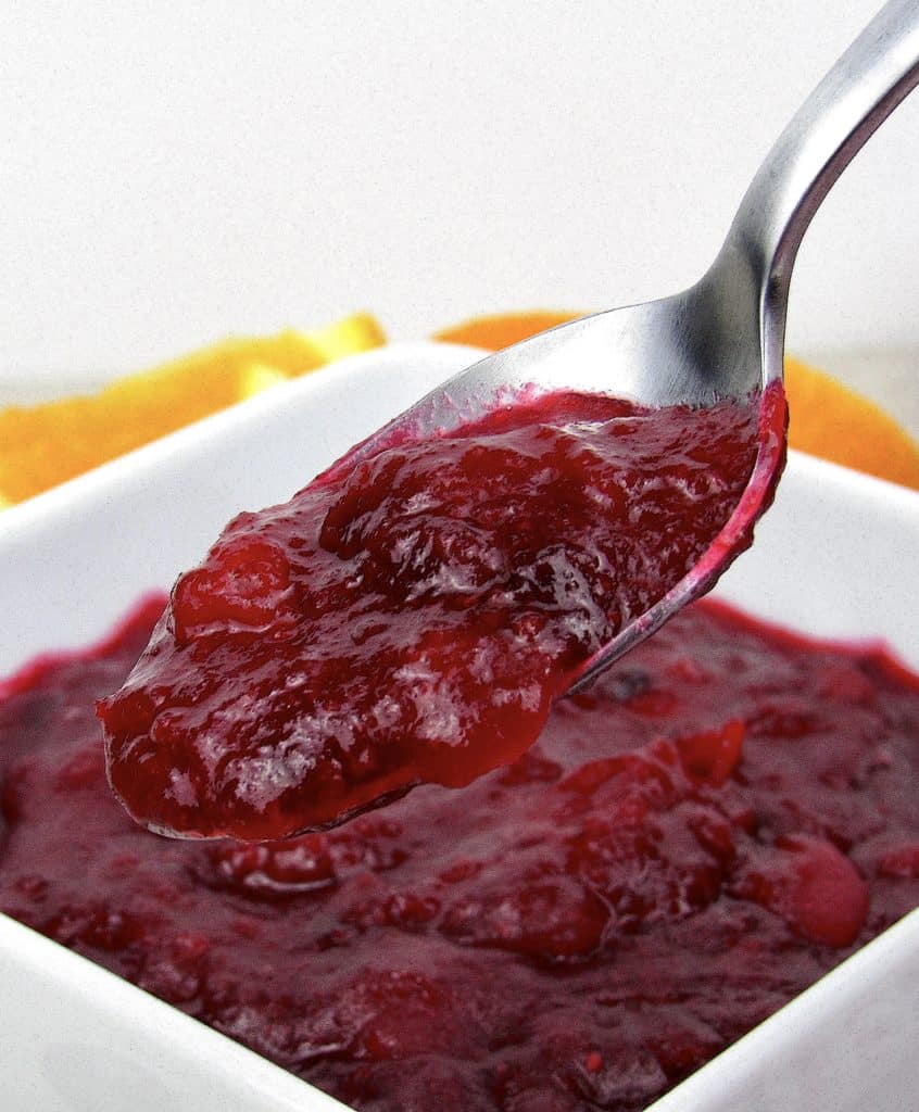 cranberry sauce in white bowl with spoonful