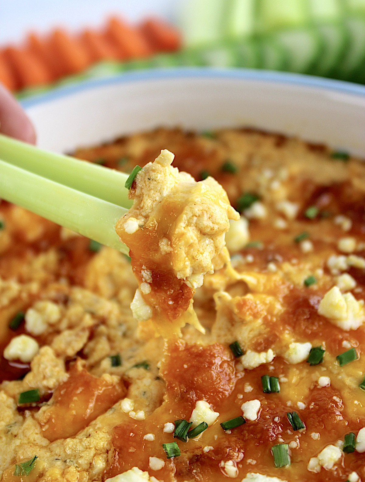 celery stick being dipped into Buffalo Chicken Dip
