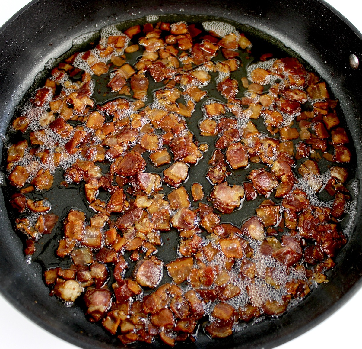 chopped bacon frying in skillet