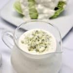 Keto Blue Cheese Dressing in glass pitcher with lettuce wedge in background