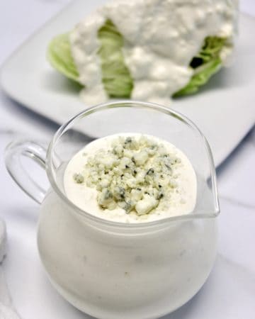 Keto Blue Cheese Dressing in glass pitcher with lettuce wedge in background