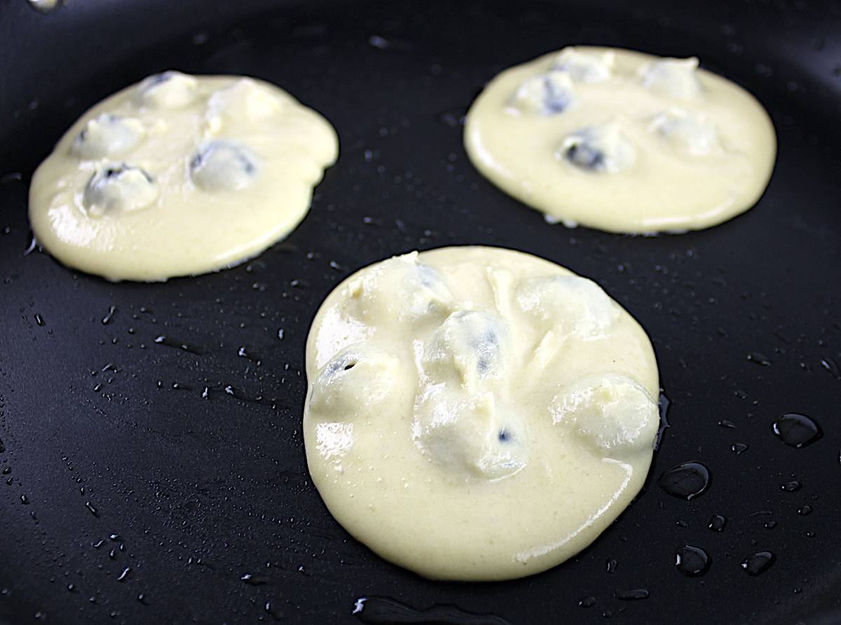 uncooked blueberry pancakes in skillet