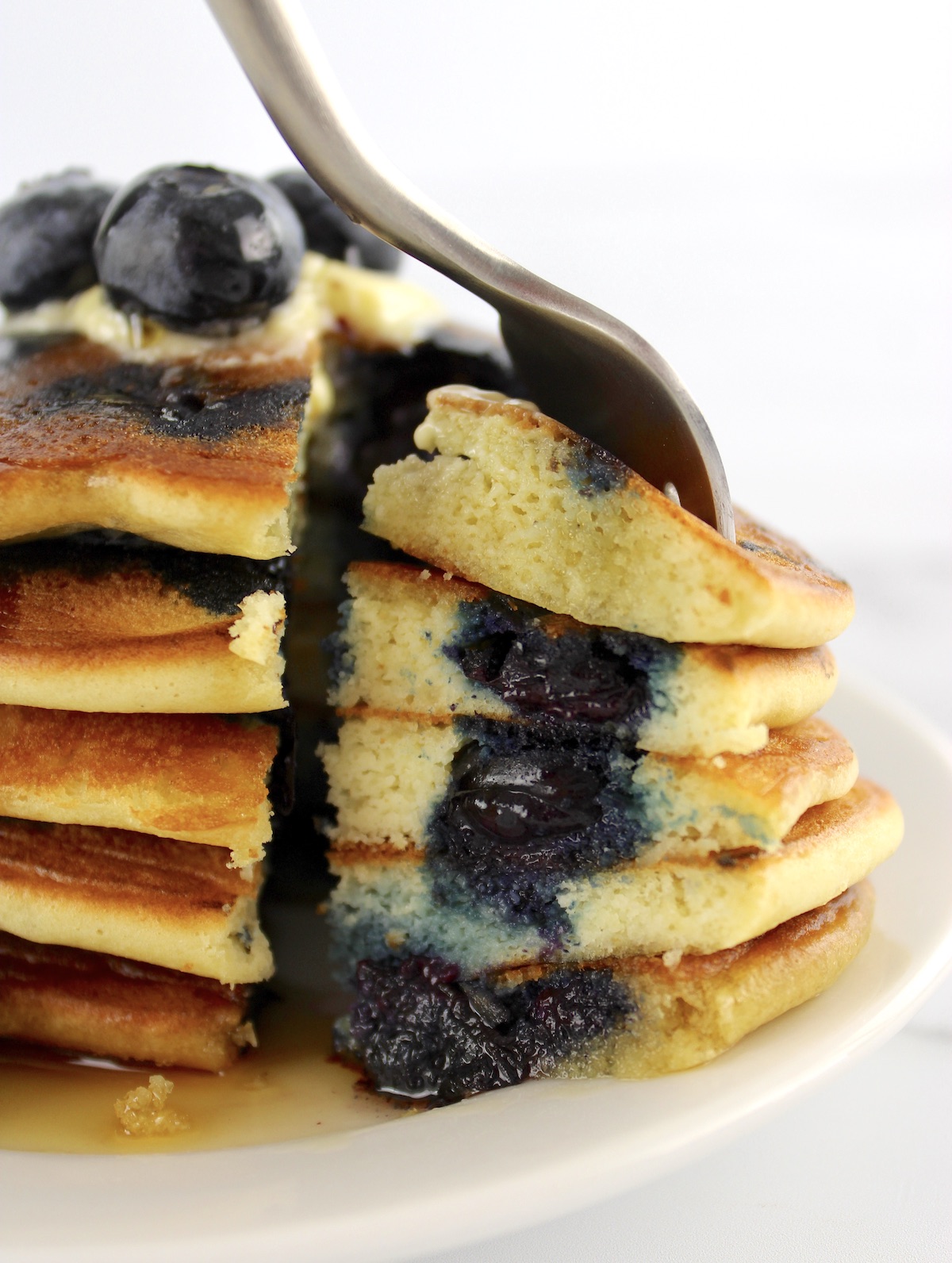 stack of Keto Blueberry Pancakes with fork cutting into