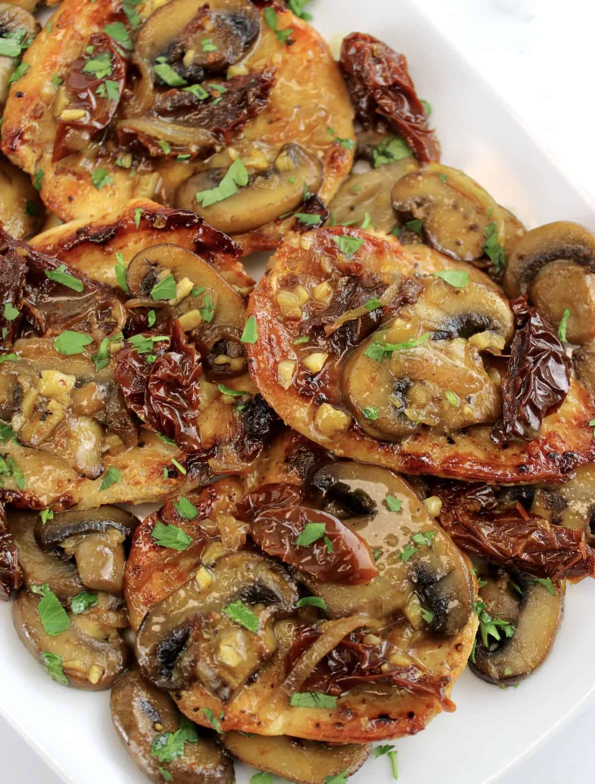 overhead view of Mushroom Chicken with Sun-Dried Tomatoes on white platter