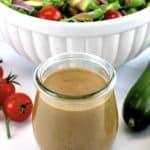 Creamy Balsamic Dressing in glass open jar with salad in background