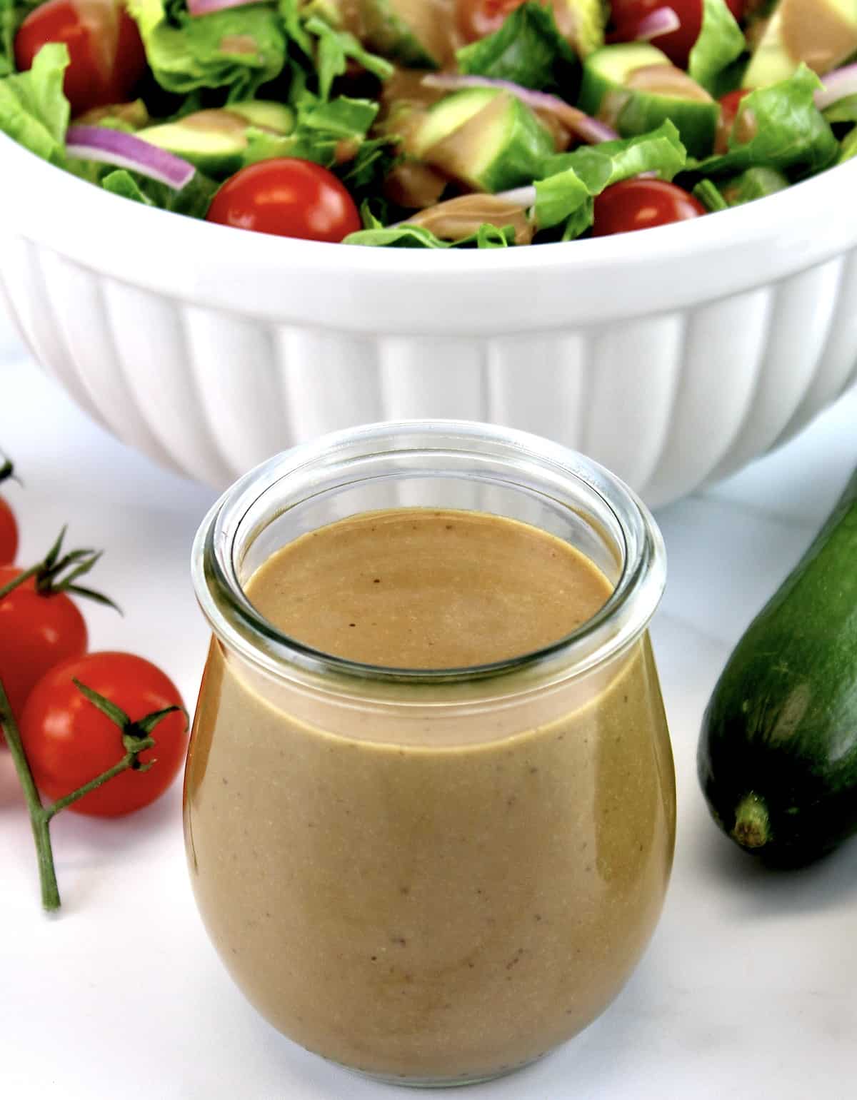Creamy Balsamic Dressing in glass open jar with salad in background