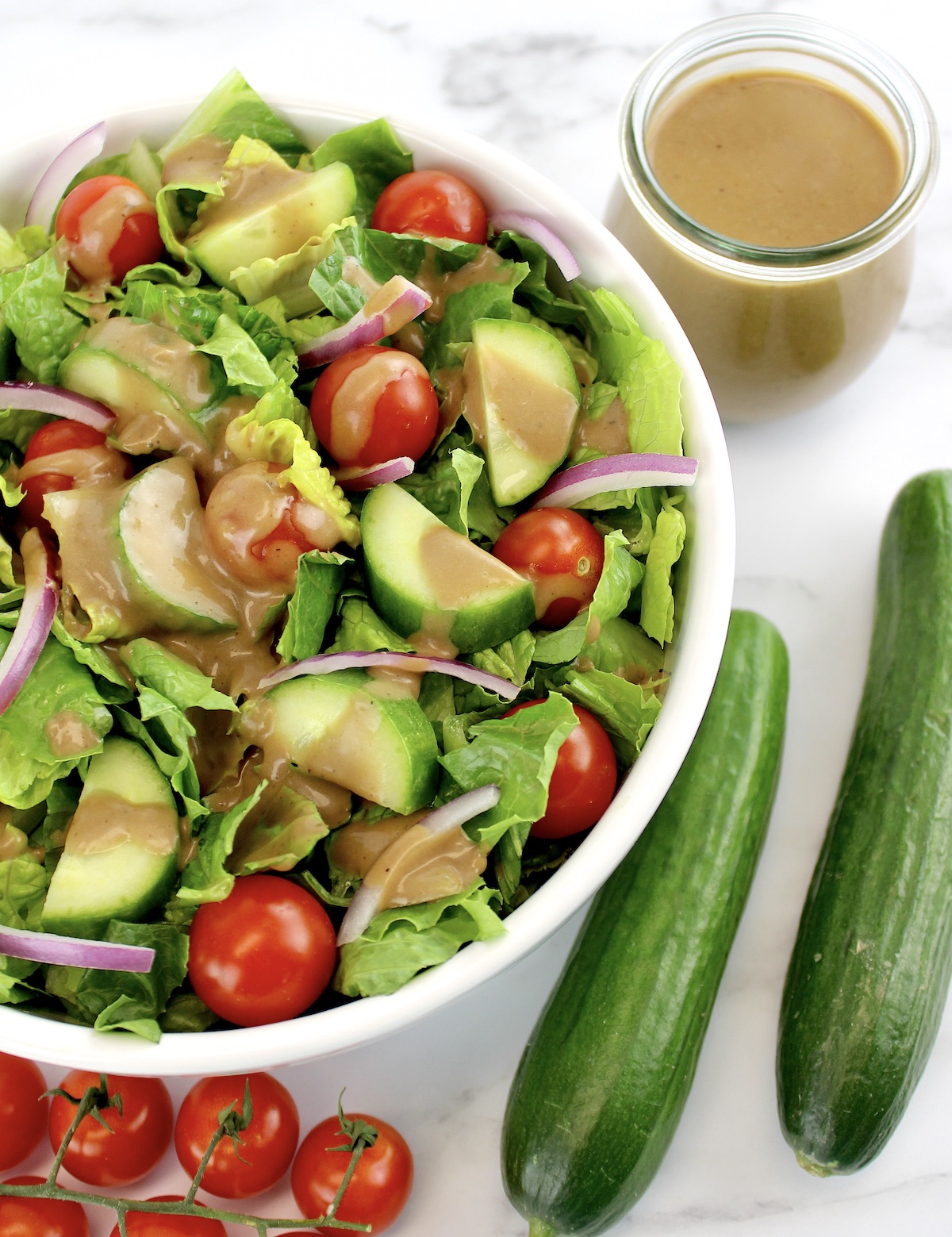 overhead view of salad with Creamy Balsamic Dressing and cucumbers on side