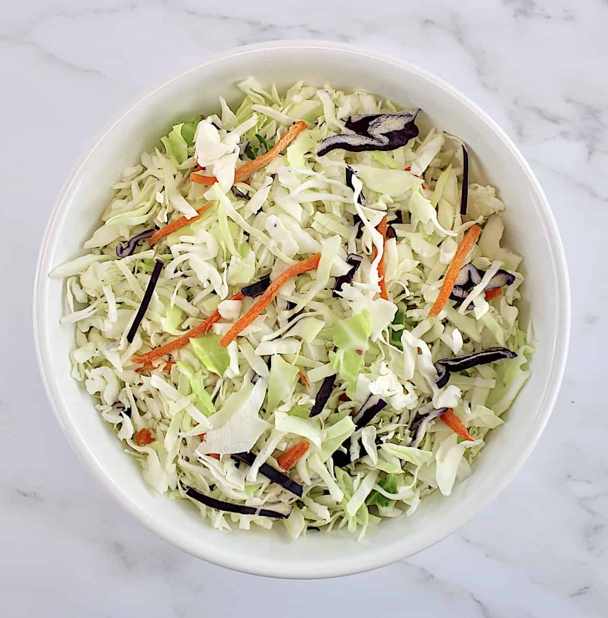 overhead view of slaw mix in white bowl