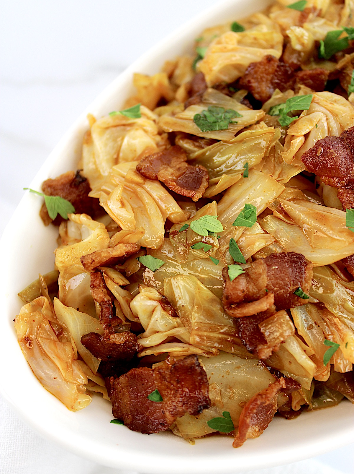 side view of Fried Cabbage with Bacon in white bowl