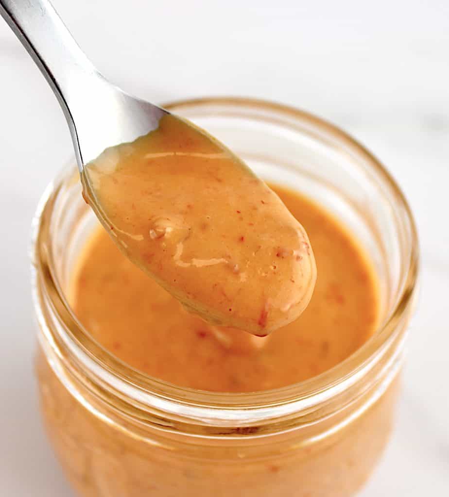 Keto Bang Bang Sauce in spoon over open glass jar