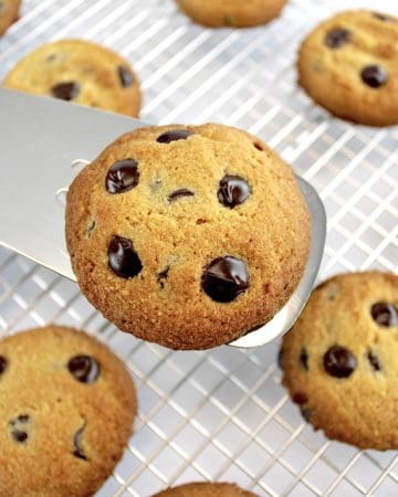 closeup of spatula holding Keto Chocolate Chip Cookie over a cooling rack
