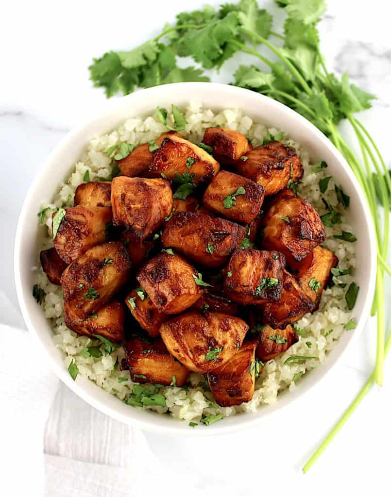 overhead view of Air Fryer Salmon Bites over cauliflower rice in white bowl