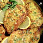 Keto Chicken Francese in skillet with lemon slices and chopped parsley