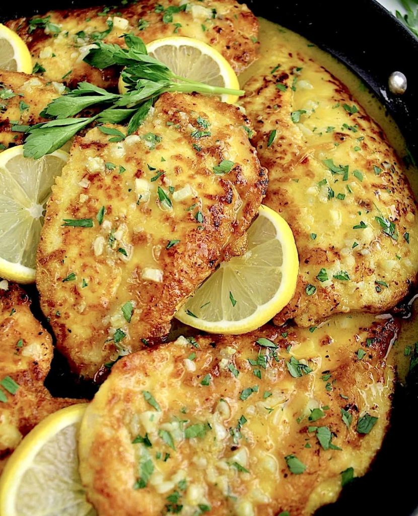 Keto Chicken Francese in skillet with lemon slices and chopped parsley